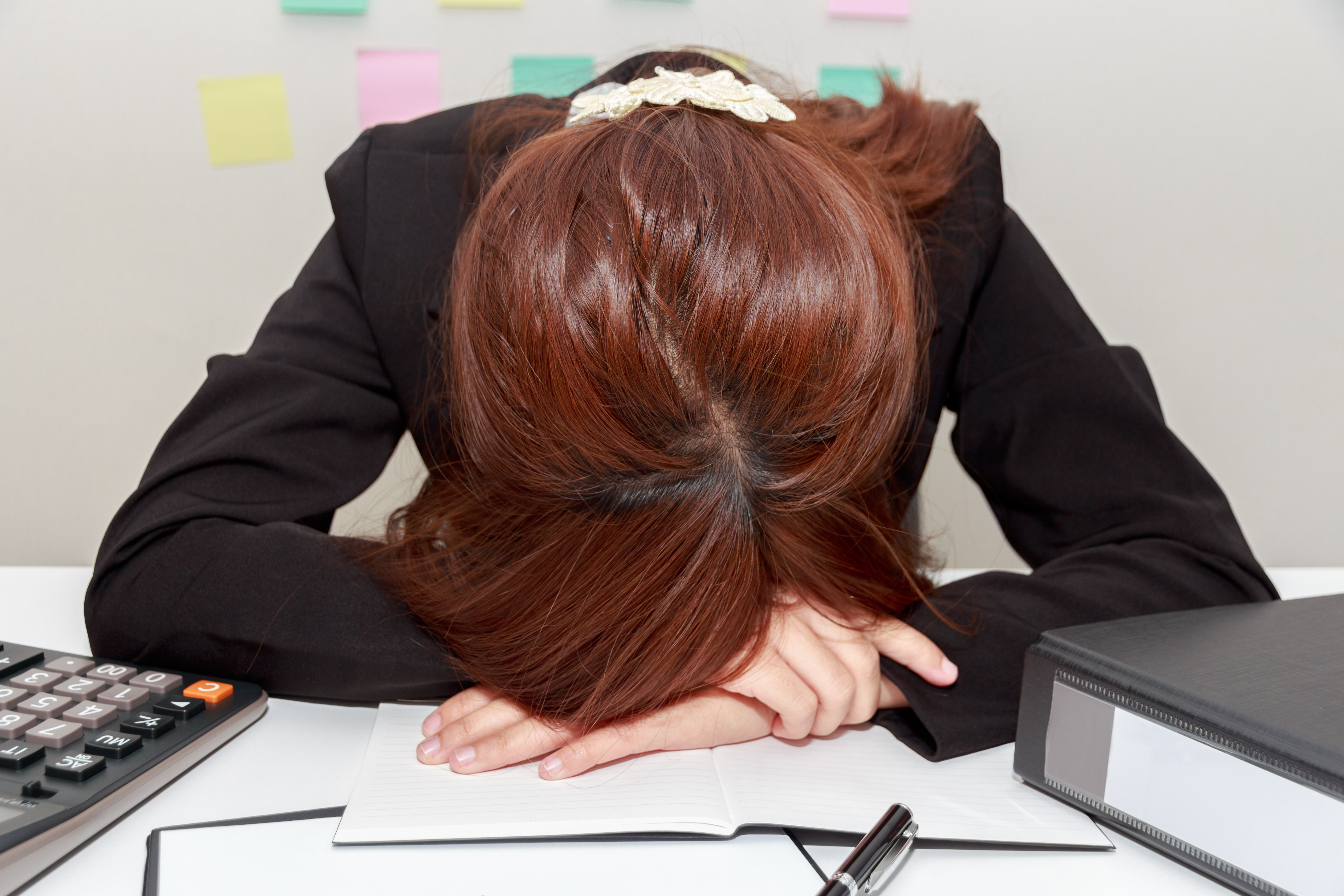 Stressed Businesswoman Bend Down The Head Or Sleep At Her Desk